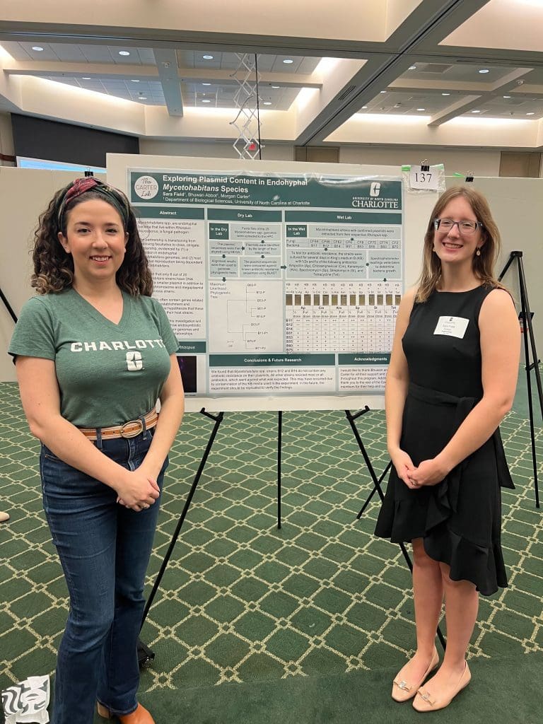 Two people standing in front of a scientific poster