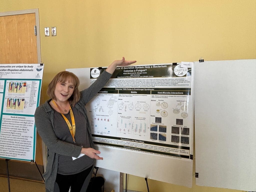 A woman posing in front of her poster