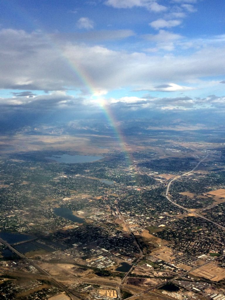 Rainbow as seen from an airplane leaving a city, capturing nicely how our amazing atmosphere is constantly a part of our lives.  Photo by Dr. Magi's sister.